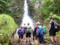 Expeditionen: Gebirgswelten – Eine Wandergruppe am Wasserfall neben dem Prinz Luitpold-Haus im Allgäu, nahe Bad Hindelang.