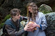 Der süße Brei – Jolanthe (Svenja Jung) und Veit von Hammerlitz (Merlin Rose) stehen auf einer Waldlichtung dicht bei einander, umfassen den magischen Topf und blicken sich tief in die Augen.