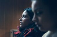 Maroni - Im Reich der Schatten – Shana Jones (Soundos Mosbah, li.) und Zoé Newashish (Inès Spiridonov, re.) sind bei der Polizei, um die Vergewaltigung zu melden. Doch einem alten Herrn detaillierte Fragen zu beantworten, ist kein Leichtes und holt die Erinnerungen wieder hoch.