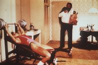 Die Miami Cops – Steve (Bud Spencer, r.) und seine Kollegin, die FBI-Agentin Irene (Jackie Castellano, l.), halten sich auf unterschiedliche Weise fit: Steve isst während Irene trainiert ...