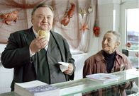 Der Dicke – Gregor Ehrenberg (Dieter Pfaff, l.) verspeist genüßlich ein Fischbrötchen. Frau Meissner (Heidy Forster, r.) freut sich, dass es ihm schmeckt.