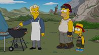 Die Simpsons – Homer (M.), Bart (r.), Marge, Maggie und Lisa verlassen ihre Heimatstadt Springfield und schließen sich einer autarken Gemeinde außerhalb der Stadt an. Dort treffen sie auf Julian Assange (l.), der ihr neuer Nachbar wird ...