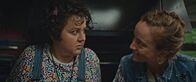Derby Girl – Marie-Josée (Salomé Diénis Meulien, l.) und Booby Mercury (Allison Chassagne, r.) sitzen in einem Food-Truck. Plötzlich wird der Wagen von einem Polizisten angehalten.