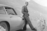 Sean Connery vs James Bond – Sean Connery als James Bond neben seinem Aston Martin DB5 in einer Szene des Films „Goldfinger“ aus dem Jahr 1964
