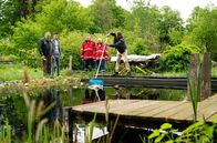Hubert ohne Staller – Die Leiche einer jungen Frau treibt nach einer wilden Partynacht in einem Gartenteich. Leon Schwarz (Patrick Mölleken, 2.v.l.), der Sohn des Hauses, beteuert vor Girwidz (Michael Brandner, l.) und Hubert (Christian Tramitz, r. mit Komparsen), dass keiner den Tod der Frau bemerkt hatte.