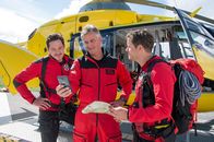 Die Bergretter – Tobias (Markus Brandl, l.), Michi (Robert Lohr, M.) und Ben (Mirko Lang, r.) checken vor dem Start in die Berglandschaft, wohin genau sie laut den vorliegenden Informationen fliegen müssen.