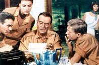Hatari – Die Wildjäger um Sean Mercer (John Wayne, Mi.), Kurt Müller (Hardy Krüger, re.), Pockets (Red Buttons, li.) und Brandy de la Court (Michèle Girardon, 2.v.l.) erfahren, dass ihre kleine Gruppe Zuwachs bekommen hat.