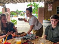 Verrückt nach Meer – Die Praktikanten Steffi Gehrlein, Tom Vajs und Laura Rotter essen im Restaurant "Dancing Rooster" des Schweizer Kochs Gunter Schnell in Vava'u (Tonga), Steffi hat dem Koch beim Lobster kochen geholfen und serviert nun ihren Freunden das Essen.