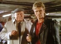 MacGyver – Thornton (Dana Elcar, l.) und MacGyver (Richard Dean Anderson, r.) prüfen eine Erfindung von MacGyver.