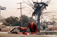 Last Action Hero – Leinwand-Cop Jack Slater (Arnold Schwarzenegger) lässt es in seinem neusten Film wieder krachen: Gerade hat er ein paar Angreifer unsanft entsorgt.
