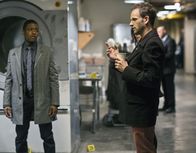 Elementary – Die Leiche des Geschäftsführers eines Nobelhotels in Manhattan wurde in einer Industriewaschmaschine gefunden. Sherlock Holmes (Jonny Lee Miller, r.) und Marcus (Jon Michael Hill, l.) sehen sich den Tatort an, um den Täter zu überführen ...