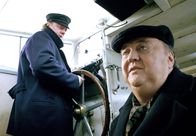 Der Dicke – Skipper Hinnerk Jansen (Peter Kurth, links) bittet Gregor Ehrenberg (Dieter Pfaff) um Hilfe.