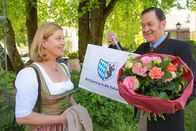 Die Rosenheim-Cops – Schretzmayer (Jürgen Tonkel, r.) trifft zufällig Marie (Karin Thaler, l.) und präsentiert ihr das Geschenk, das er für seine japanischen Gäste besorgt hat.