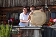 Heimatleuchten – Resi und Sepp Heim posieren für ein Foto mit ihrem Alm-Berkäse "Koasa Mand´l"