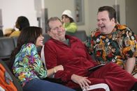 Modern Family – Jay (Ed O'Neill, M.) versucht die Tatsache, dass Gloria (Sofia Vergara) neben Cameron (Eric Stonestreet) die komplette Familie auf ihren Kurztrip nach Hawaii eingeladen hat, mit Humor zu nehmen.