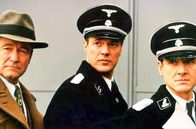 Der Stellvertreter – Von Rutta (Erich Hallhuber, li.), Höss (Sebastian Koch, Mi.) und der Arzt (Ulrich Mühe, re.) offenbaren Kurt Gerstein, wofür sie das von ihm erfundene Desinfektionsmittel Zyklon B verwenden – zur Vergasung von Juden.