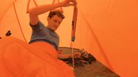 CheXpedition – Checker Julian wacht in einem nassen Zelt auf.