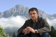 Der Bergdoktor – Nachdenklich sitzt der Bergdoktor Martin (Hans Sigl) vor seiner Praxis.