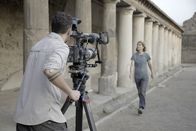 Schätze des Römischen Reichs – Produzent/Regisseur Mat Stimpson (L) filmt Monika Trümper, wie sie auf die Kamera zugeht und die Stabianischen Bäder in den Ruinen von Pompeji bewundert. (Credit: National Geographic/Annamaria Craparotta)