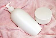 Start Now by Judith Williams – Weiße Kosmetikflasche und Cremetiegel auf rosa Frottee in Großaufnahme