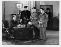 Dick und Doof hinter Schloss und Riegel – Stan (Stan Laurel – zweiter von rechts) und Ollie (Oliver Hardy – dritter von rechts) sind wegen Alkoholverkaufs verhaftet worden und werden dem Gefängnisdirektor Warden (Wilfred Lucas – links) vorgeführt.