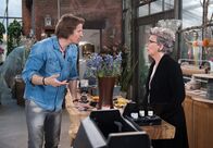 Rote Rosen – ARD ROTE ROSEN FOLGE 1987 Uhr im ERSTEN. Inge (Peggy Lucak, r.) und Ben (Hakim Michael Meziani, l.) stellen erschrocken fest, dass nicht genügend frische Blumen für die Trauerkränze da sind.