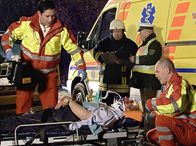 In aller Freundschaft – Dr. Brentano (Thomas Koch, links) wird mit dem Notarztwagen zu einem Autounfall gerufen. Erst als Prof. Simoni an der Unfallstelle ankommt, stellt sich heraus, dass der Verletzte Prof. Hanno Hinze (Karl Kranzkowski, liegend) ist. Rechts: 3 Komparsen .