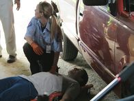 Abgründe - Unfassbare Verbrechen – A paramedic sitting kneeling next to Karl's Levi's dead body in the garage.