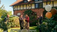 Rote Rosen – v.l. Daniel Fritz) lockt Jess (2 v.r Juana Nagel) in den Garten und die beiden erfahren, dass sie ein Mädchen bekommen. Julius (r. Jan Stapelfeldt) hält alles fest.