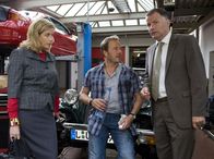 In aller Freundschaft – Roland Heilmann (Thomas Rühmann, rechts) schleppt Sarah Marquardt (Alexa Maria Surholt, links) in eine Autowerkstatt. Dort treffen sie auf den gut aussehenden Benjamin Wittenberg (Till Demtröder), den Sarah für einen Mechaniker hält. Benjamin Wittenberg hingegen, hält Roland für Sarahs Ehemann.