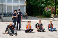 neoriginal: Aufgestaut – Polizist Wuttke (Daniel Donskoy, 3.v.l.) und seine Kollegin Strasser (Altine Emini, 2.v.l.) rufen Verstärkung. Alleine können sie die Protestierenden (von links: Joachim Seemann, Valerie Stoll, Adrian Grünewald, Maria Goletz) nicht vom Asphalt lösen. Doch die Straßen sind dicht und die Kollegen bei anderen Klimaprostestaktionen im Einsatz.