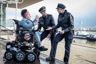 Notruf Hafenkante – Die Aktivistin Cora Liberti (Kübra Sekin, l.) hält Melanie (Sanna Englund, r.) und Mattes (Matthias Schloo, M.) davon ab, ihr zu helfen. Sie leidet an der Glasknochenkrankheit, bei der jeder falsche Griff zu Brüchen führt.