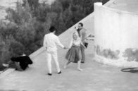 Paparazzi – Brigitte Bardot hat Spaß mit ihren Co-Stars am Filmset von Jean-Luc Godards „Die Verachtung“ – doch die Presse lauert ihr auf.