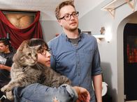 Der Katzenflüsterer – Cat owner Alison holding Pancake as she and Dylan look forward.