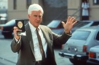 Die nackte Kanone – Lt. Frank Drebin (Leslie Nielsen) tappt von einem Fettnäpfchen ins nächste.