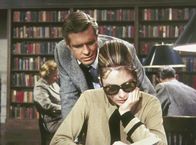 Frühstück bei Tiffany – Der verkrachte Schriftsteller Paul Varjak (George Peppard) besucht Holly Golightly (Audrey Hepburn) in der Stadtbibliothek, wo sie sich über das Land ihres künftigen Millionärsgatten informiert.