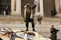 The Dark Knight Rises – Vor dem Black-Gate-Prison prangert Bane (Tom Hardy) vor laufenden Kameras Harvey Dent als Mörder an und will das Gefängnis stürmen lassen, um die inhaftierten Schwerverbrecher für seine Zwecke einzuspannen.