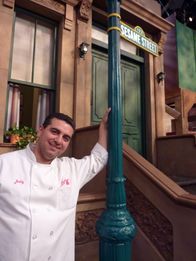Cake Boss: Buddys Tortenwelt – Sesame Street Cake. Buddy poses next to the famous Sesame St sign.