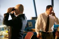 Mayday - Alarm im Cockpit – REENACTMENT - The Tenerife Controller (played by Rodrigo Fernandez-Stoll) is on the phone and the Junior Investigator (played by background performer Marcelo Pinero) looks out the tower through binoculars. (Photo Credit: Cineflex/Ian Watson)