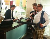 Heißmann + Rassau – Der Hotelmitarbeiter (Oliver Severin) hat das Vergnügen, Anneliese (Martin Rassau, Mitte) und Georg (Volker Heißmann, rechts) im schönen Bad Kissingen begrüßen zu dürfen.