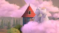 Mumintal – Mumintroll (li.) hat einen schönen Traum. Er schwebt mit Snorkfräulein (re.) auf einer rosa Wolke vor dem Muminhaus.