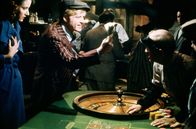 Der Clou – Johnny (Robert Redford, 2.v.l.) kauft sich von seinem Anteil des ergaunerten Geldes einen roten Anzug, holt eine Freundin namens Billie (Eileen Brennan, li.) ab und geht mit ihr Roulette spielen.