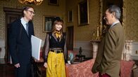 The Outlaws – Lady Gabby (Eleanor Tomlinson, M.) ist aufgeregt. Endlich treffen sie und Greg (Stephen Merchant, l.) ihren Vater (Richard E. Grant, r.), um über ihr heißersehntes Festival zu sprechen. Was wird er zu Gabbys Herzensprojekt sagen?