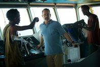 Captain Phillips – Mit finsteren Blicken und geübter Härte stürmen die somalischen Piraten Muse (Barkhad Abdi, l.) und Najee (Faysal Ahmed, r.) das Steuerhaus eines riesigen Frachters und bedrohen den Kapitän Richard Phillips (Tom Hanks, M.).