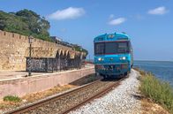 Mit dem Zug ... – Einfahrt in Faro: Der Zug fährt zwischen der Lagune und der Stadtmauer der Altstadt entlang.