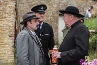 Father Brown – Inspector Mallory (Jack Deam, l.), Sergeant Goodfellow (John Burton, 2.v.l.) und Father Brown (Mark Williams, r.) besuchen eine moderne politische Fassung eines Theaterklassikers.