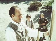 Unsere kleine Farm – Nels Oleson (Richard Bull, l.) bringt ein Plakat an, auf dem für einen Boxkampf geworben wird. Laura (Melissa Gilbert, r.) und Andy (Patrick Laborteaux, M.) sind daran sehr interessiert.