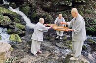 GEO Reportage – Geun Bum Sunim, Wookwan Sunim und Yeon il Sunim (v.l.) waschen Wurzeln im Fluss.