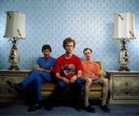 Napoleon Dynamite – Napoleon Dynamite (Jon Heder, M.) ist ein ganz besonderer Typ. Seine Tage verbringt er damit, Fantasy-Bestien zu zeichnen, sich mit seinem Bruder Kip (Aaron Ruell, r.) zu prügeln und seinem hinterlistigen Onkel Rico (Jon Gries, l.) aus dem Weg zu gehen ...