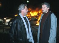 Tatort – Blankes Entsetzen ist den Münchner Kriminalhauptkommissaren Ivo Batic (Miroslav Nemec, links) und Franz Leitmayr (Udo Wachtveitl) ins Gesicht geschrieben, als der Dienstwagen brennt.